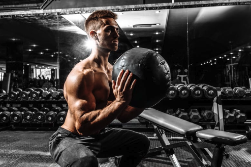 Male athlete performing wall balls in the gym